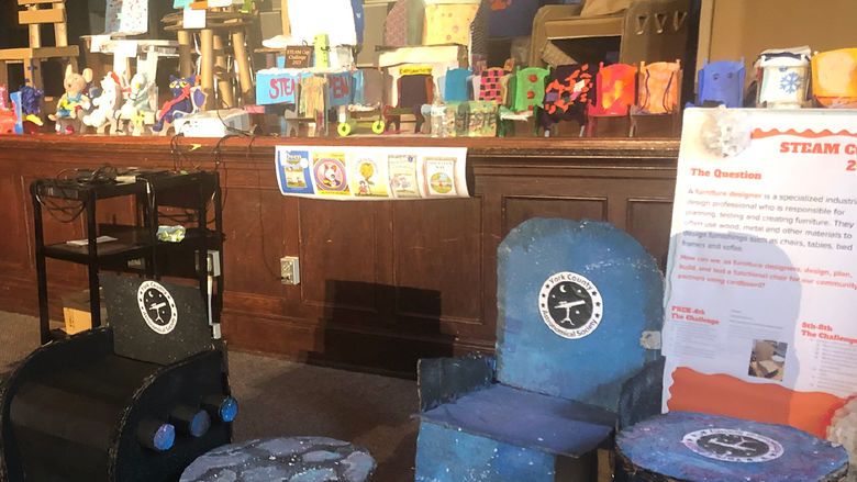 Variety of chairs and tables made from cardboard on display