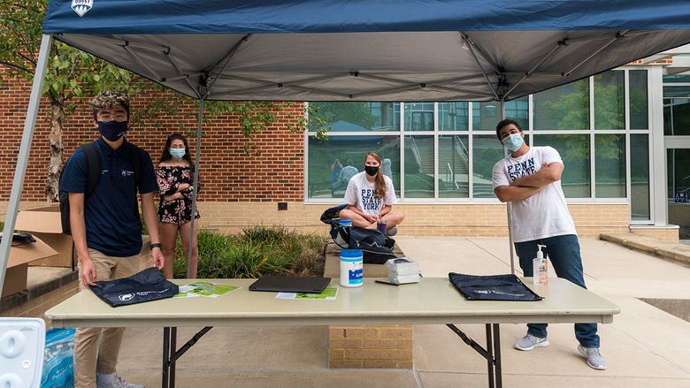 Students working at the Just Ask Me tent on the first day of classes.