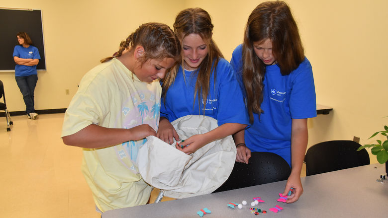 Three girls filling bean bag on classroom