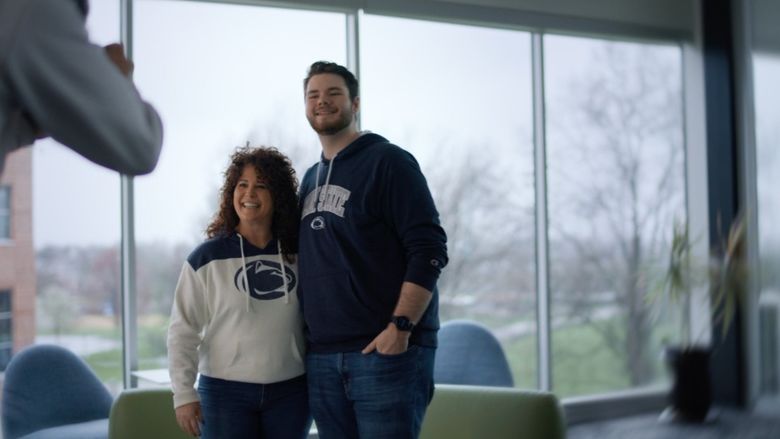 Two people wearing Penn State sweatshirts pose for a picture