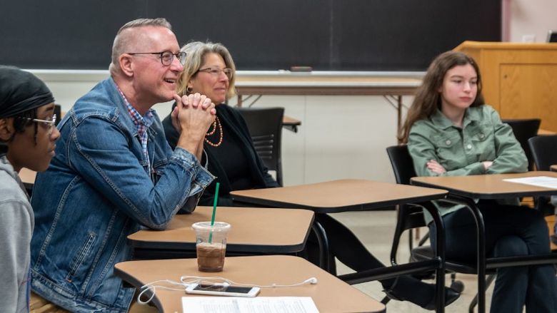 Laureate William Doan holds a conversation in an English class.