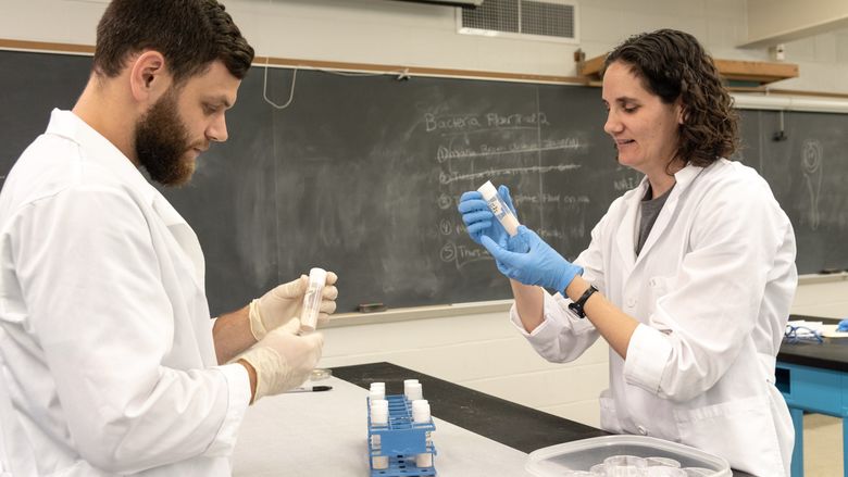 Dr. Anne Vardo-Zalik and Greg Lutz Examining Specimens While Performing Research