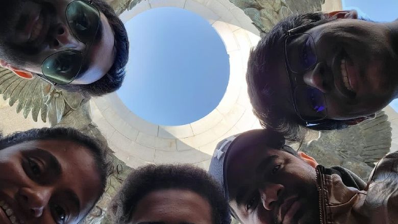 A group of students looking down at a camera in a circle