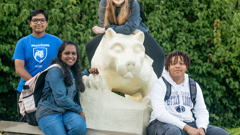 Students sitting on the Nittany Lion Statue.