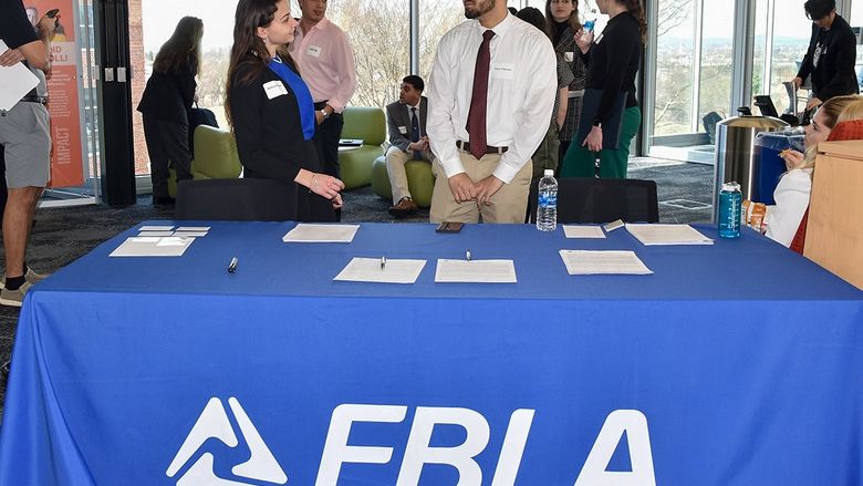 Students dressed in professional clothing networking with each other