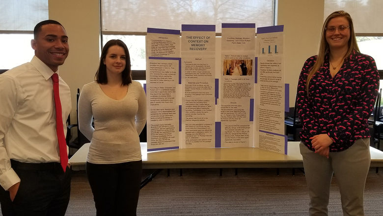 Psychology students presenting their project at a research fair.