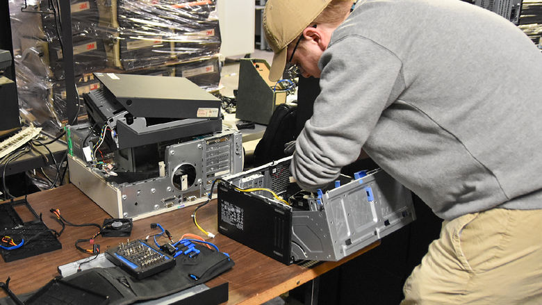 Caucasian male student working on computer equipment