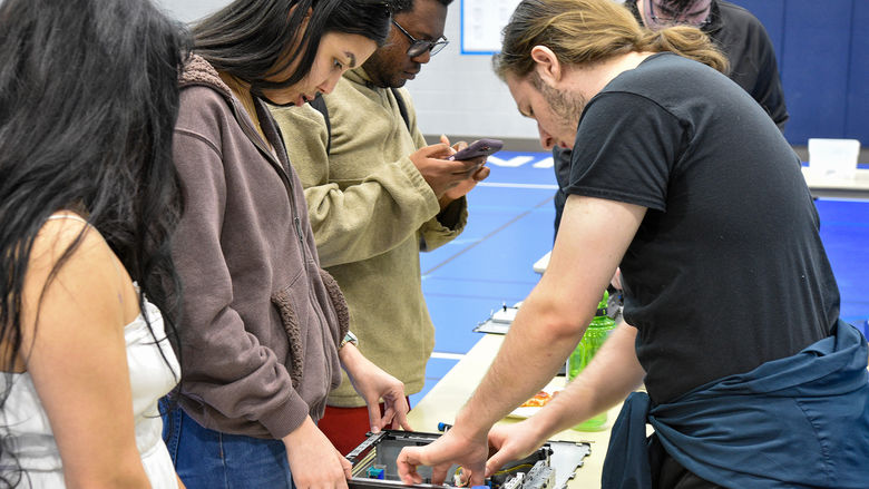 Members of SCROUNGE (Students for Computer Recycling to Outfit Underrepresented Nonprofit Groups in Education) teaching the campus community how to recycle old computer parts.