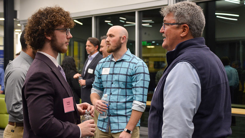 Graham student and industry professional having a conversation in Polli Hall.