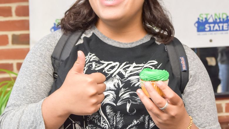 A student with a green cupcake during a Stand for State event.