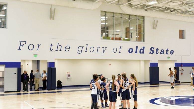 Penn State York Women’s Basketball huddling in the middle of the gym.