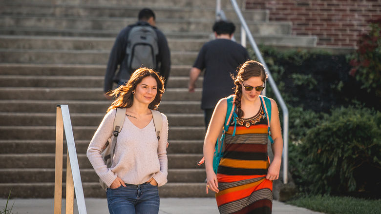 Students walking down the steps behind the John J. Romano Administration Building.