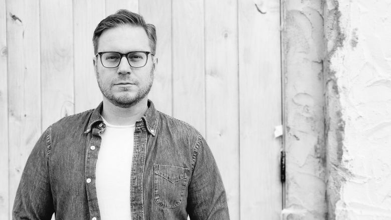 Black and white photo of a person wearing glasses.