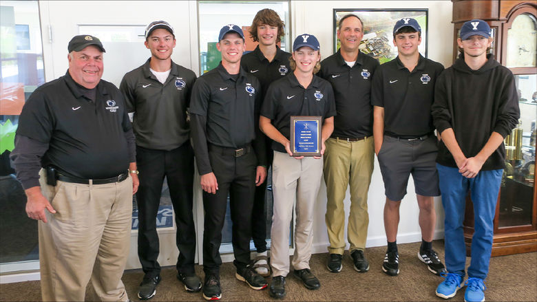 Eight older and younger men  with golf trophy.