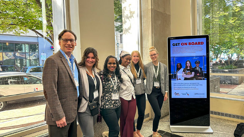 One male and five female college students pose for a picture at the women's conference in Philadelphia.