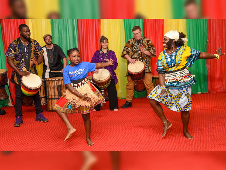 Group of African American and white performing dancing and playing instruments.
