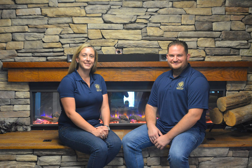 Adult woman and man sittingin front of a stone fireplace