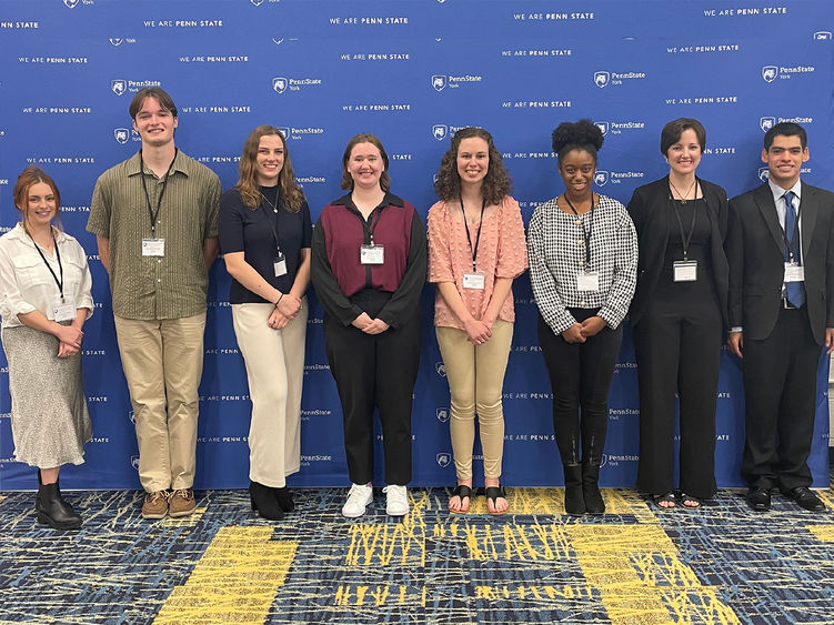 Eight student research award-winners standing in fromt of a banner