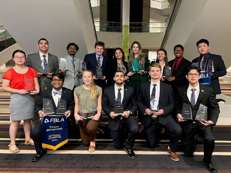 Group of young men and women holding awards.