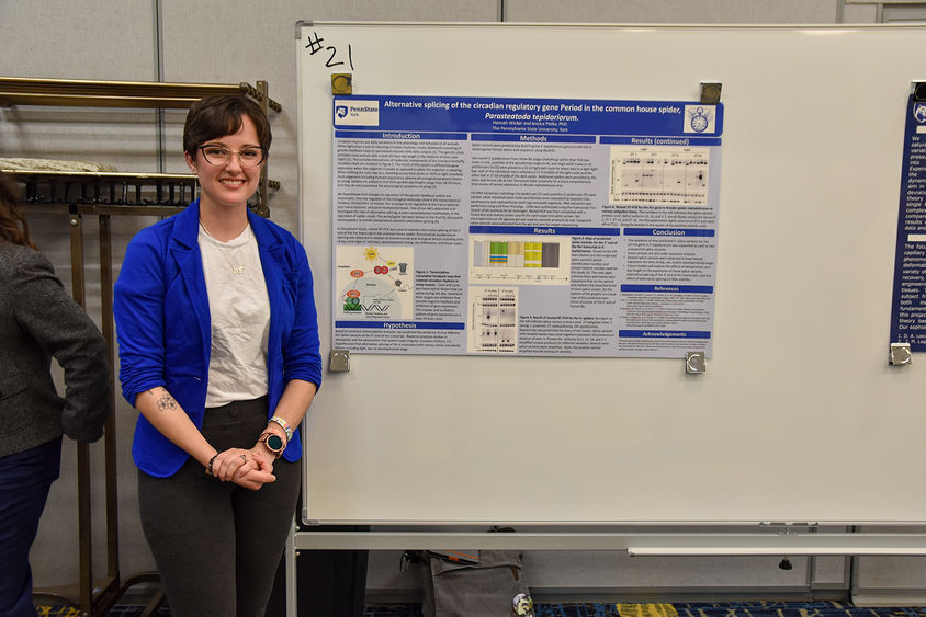 Female caucasian student standing in front of science display poster