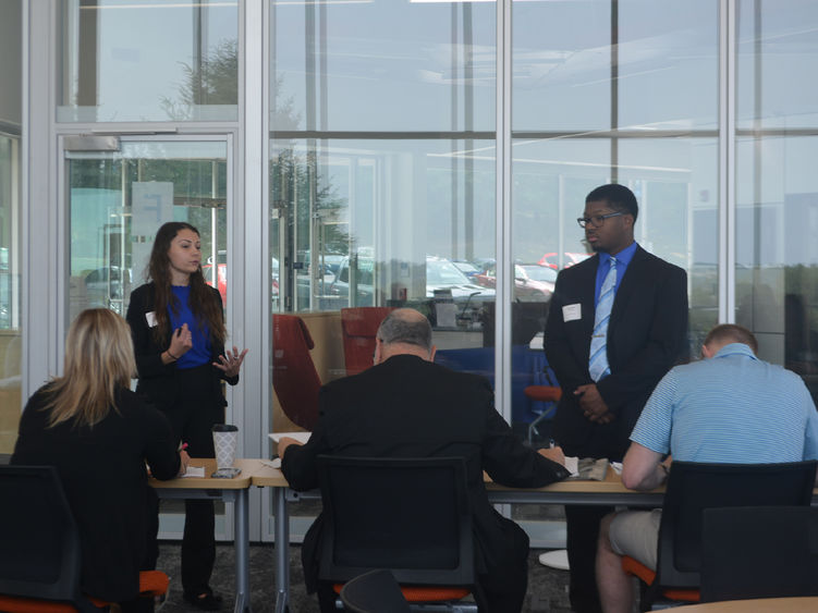 Two students present to a group of judges