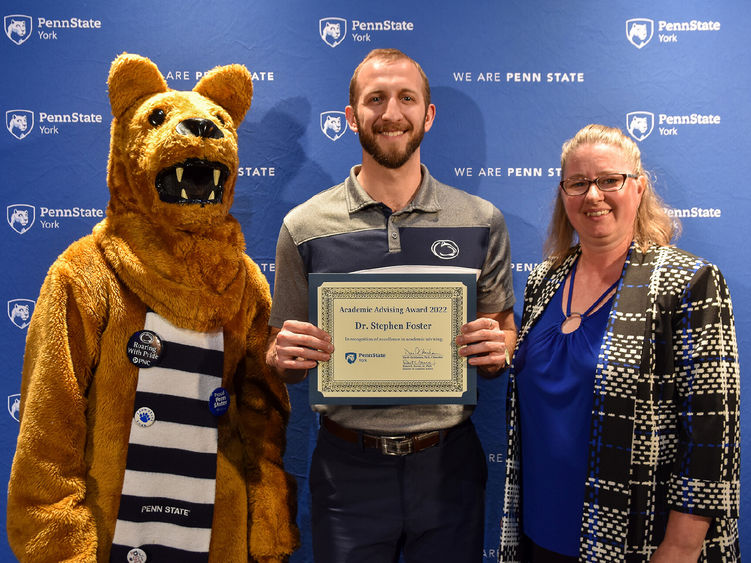 Nittany Lion character and a male and femal faculty member during award presentation