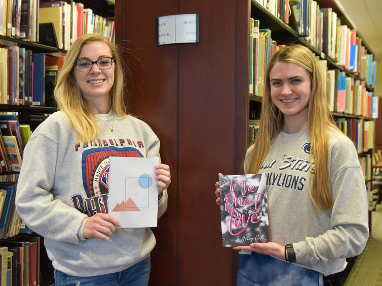 Female with long blood hair and glasses, left, holding a book, female with long blonde hair, right, holding a book.