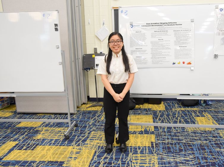 Female student standing in front of a whiteboard.